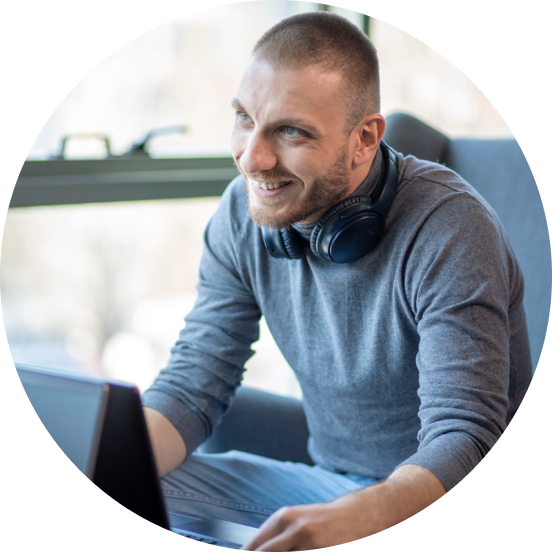 Man sitting in front of a laptop smiling